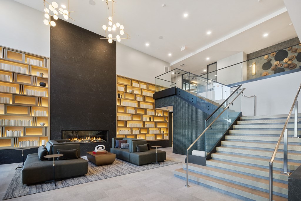 a lobby with couches and a staircase and a fireplace