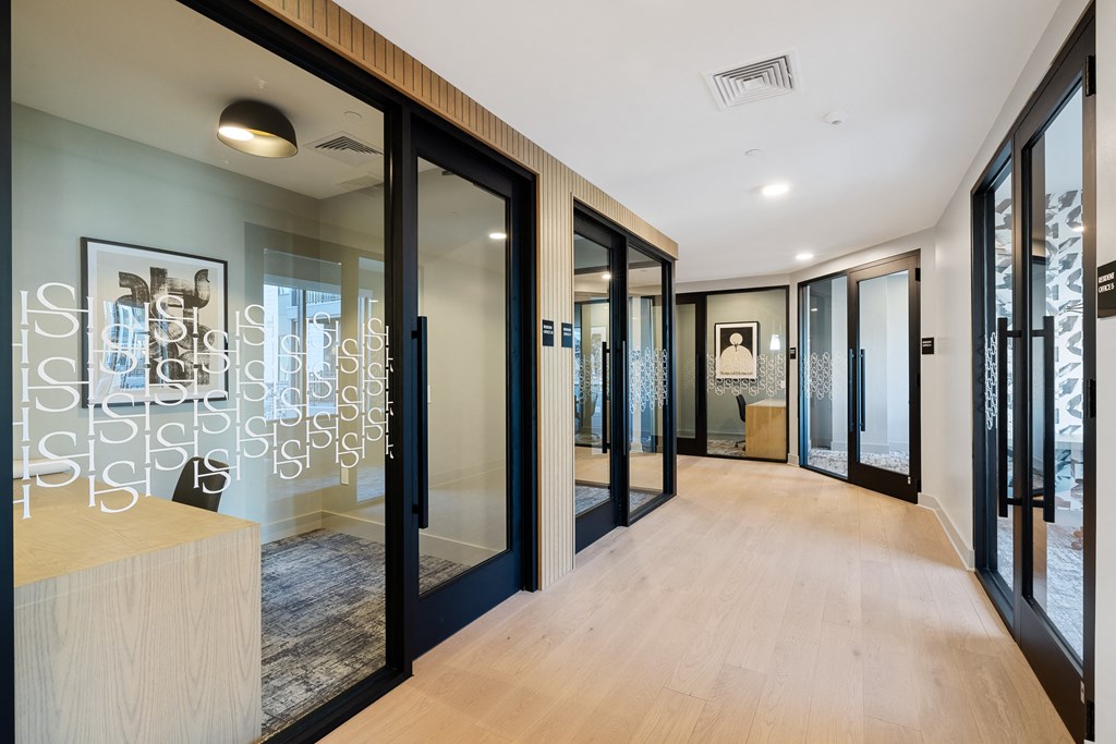 a long hallway with glass doors and a reception desk
