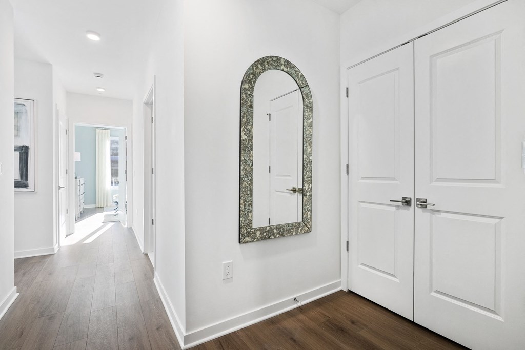 a hallway with white doors and a mirror on the wall