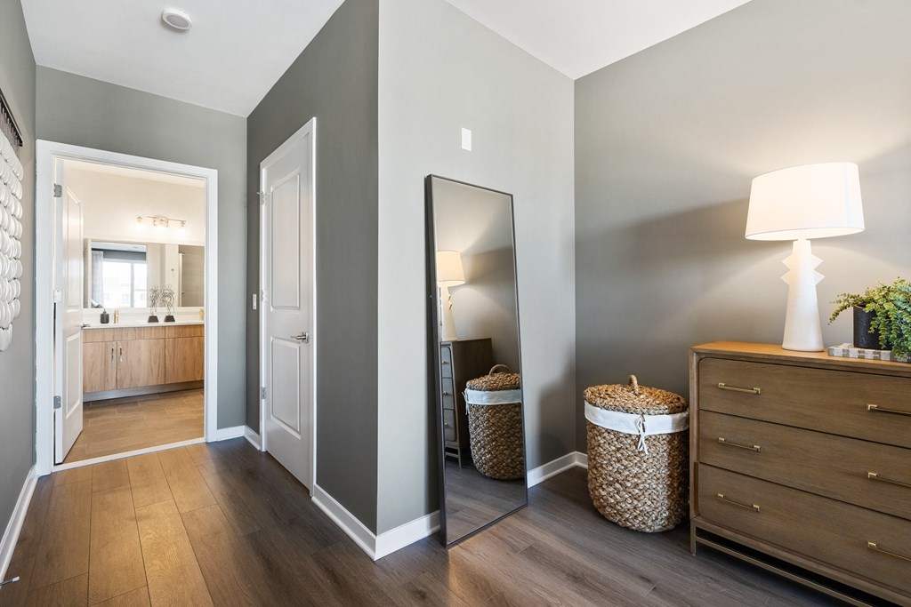 a hallway with a mirror and a dresser and a bathroom