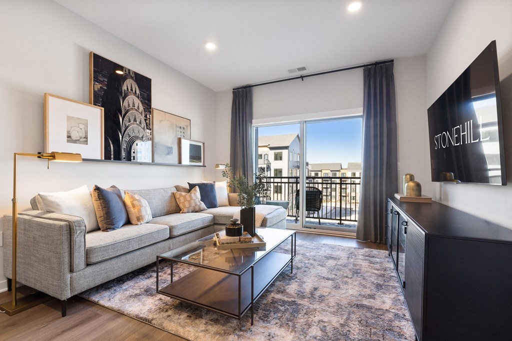 an apartment living room with a couch and a coffee table and a balcony