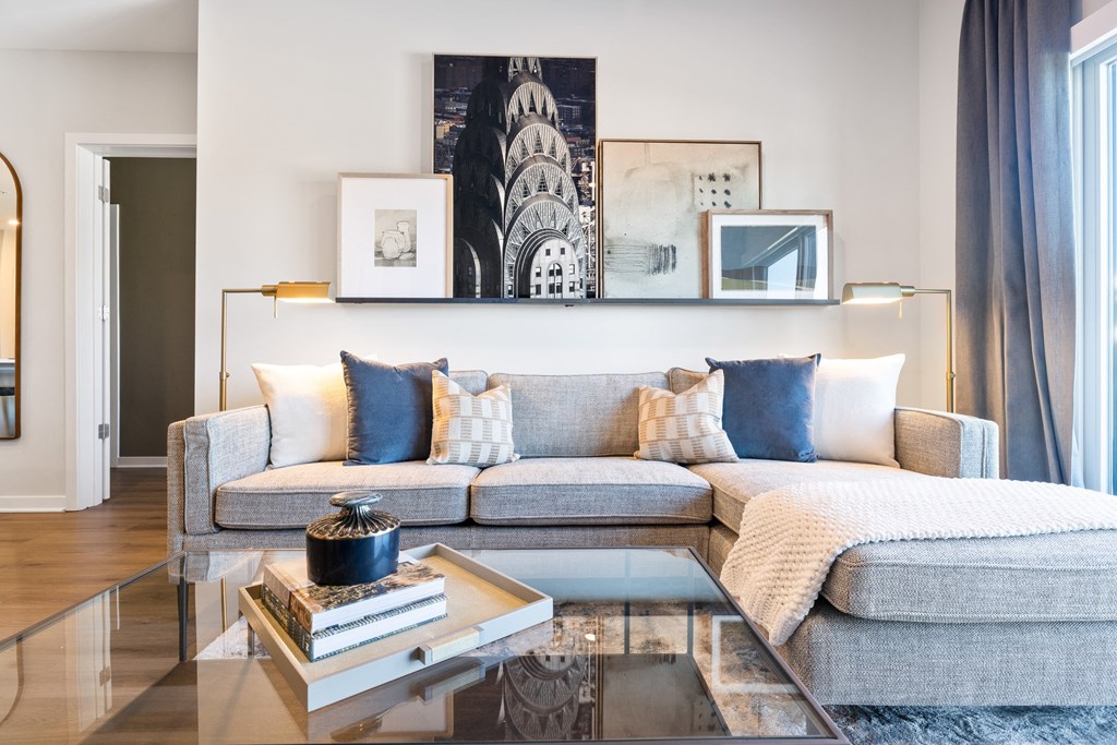 a living room with a gray couch and a glass coffee table