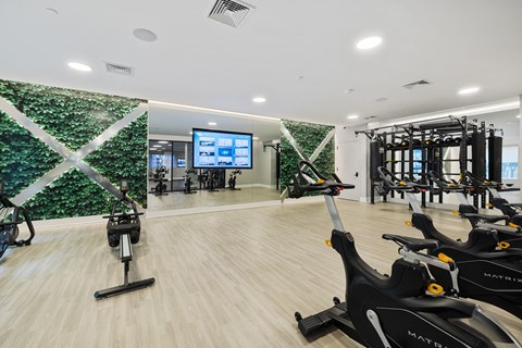 a gym with exercise machines and a wall covered in green vegetation at The Ivy, New Jersey
