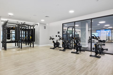 a gym with weights and cardio machines on the floor and a glass wall at The Ivy, Chatham, 07928