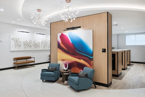 a lobby with chairs and a large painting on a wall at The Ivy, Chatham