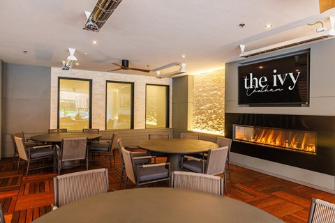 a dining room with tables and chairs and a fireplace at The Ivy, New Jersey