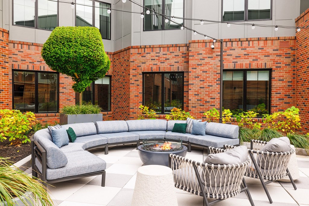 an outdoor patio with couches and chairs and a fire pit at The Ivy, Chatham New Jersey