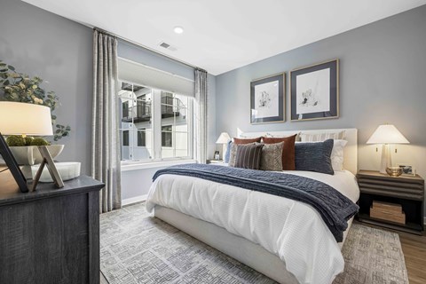 A bedroom with a large bed and two lamps.