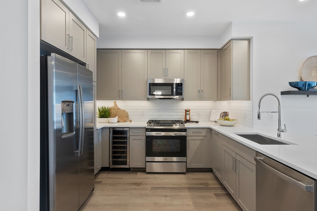 A modern kitchen with a stainless steel refrigerator and a microwave above the stove at The Reserve at Pearl River Apartments, Pearl River, NY