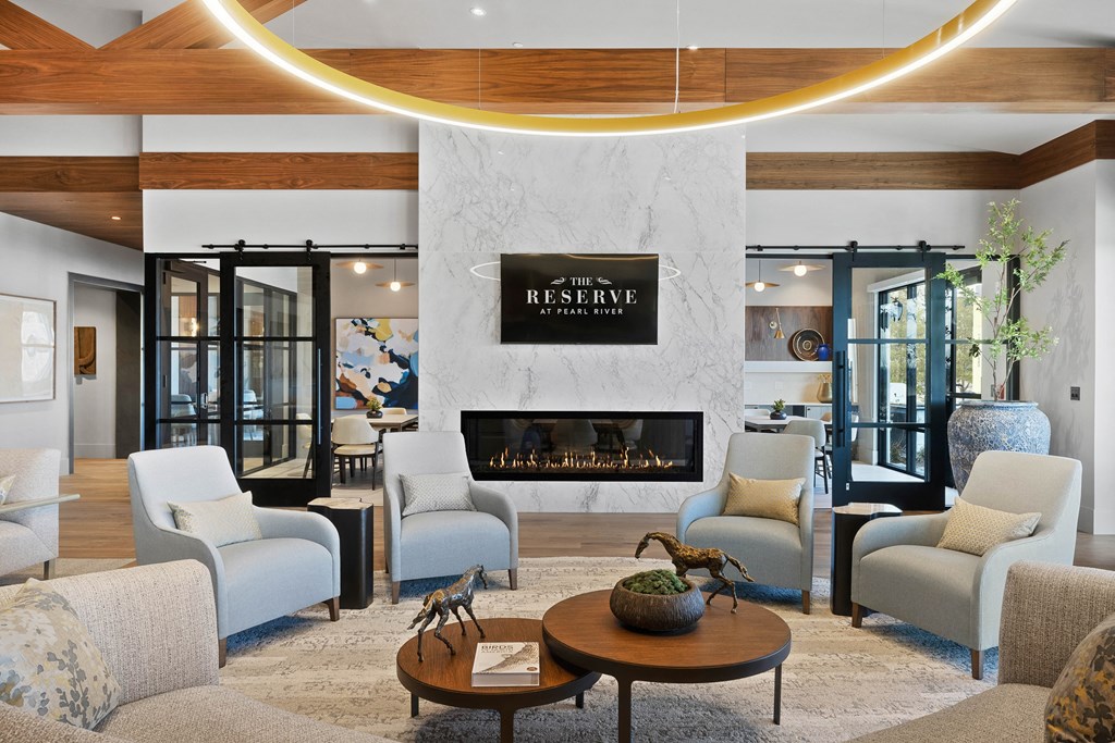 A living room with a fireplace at The Reserve at Pearl River Apartments, Pearl River