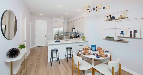 a dining area with a table and chairs next to a kitchen at The Enclave, Jersey City