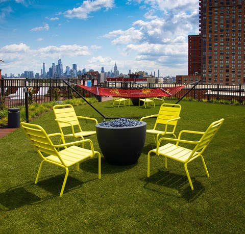 a group of yellow chairs sitting around a fire pit at The Enclave, Jersey City, New Jersey