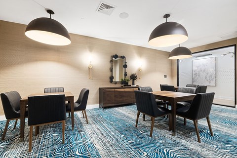 a dining room with tables and chairs and lights at The Ivy, Chatham