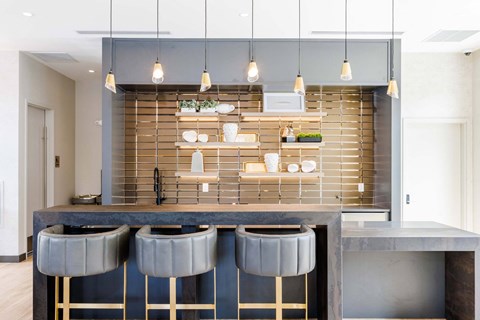a kitchen with a marble counter top and three stools