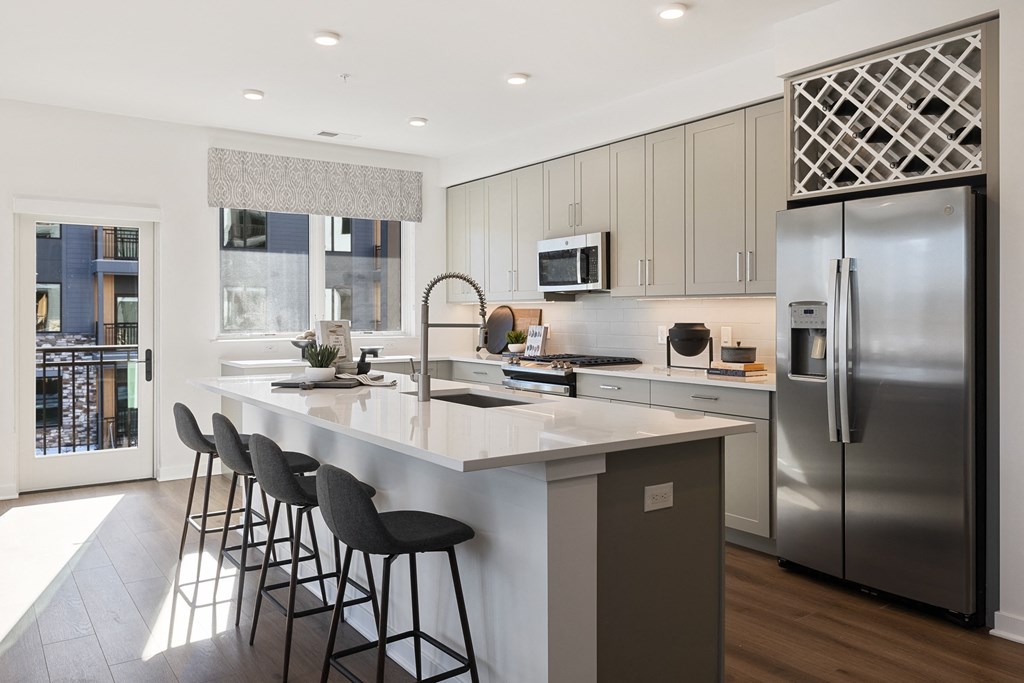 a kitchen with a large island and stainless steel appliances