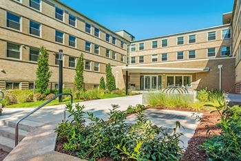 a large brick building with a garden in front of it at Carver and Slowe Apartments, Washington, 20001