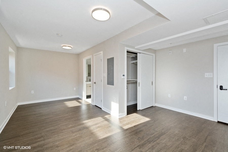 a bedroom with hardwood floors and white walls at Carver and Slowe Apartments, Washington, DC