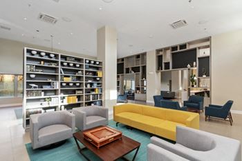 a community lounge room filled with furniture and a large bookshelf at Carver and Slowe Apartments, Washington, DC