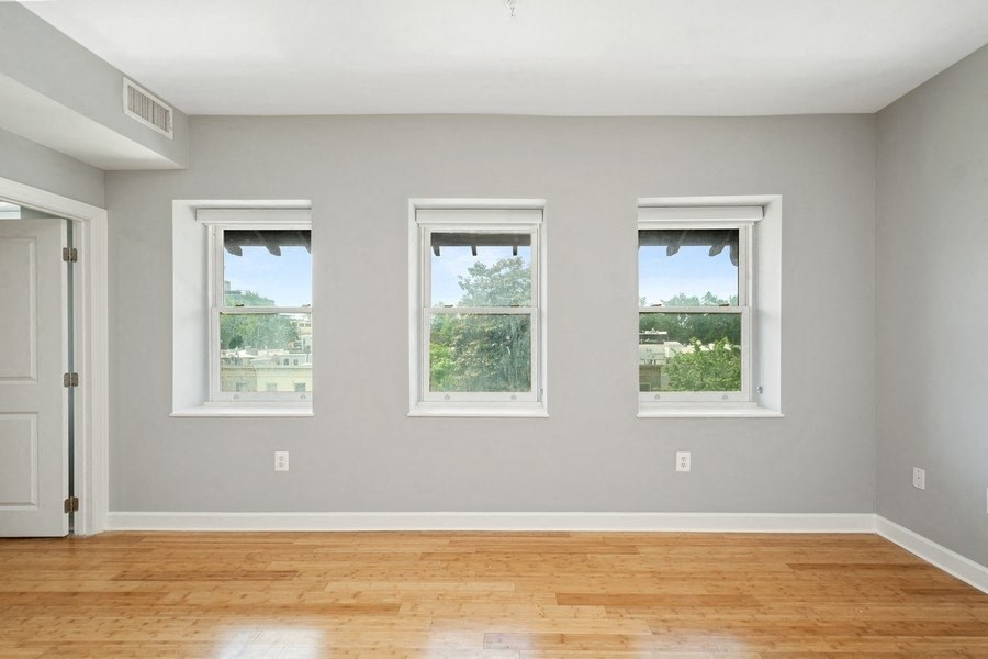 an empty room with three windows and a door