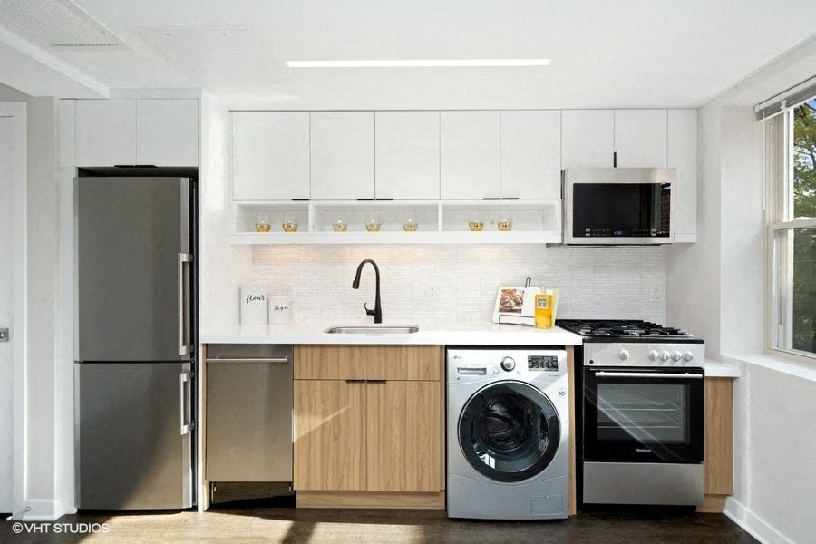 a kitchen with white cabinets and stainless steel appliances at Carver and Slowe Apartments, Washington, DC, 20001
