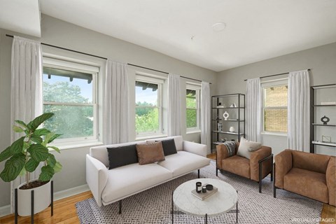 a living room with a white couch and two chairs