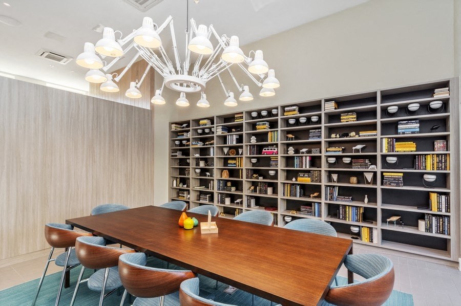 a room with a table and chairs and a large bookshelf in the background at Carver and Slowe Apartments, Washington, Washington, DC 20001