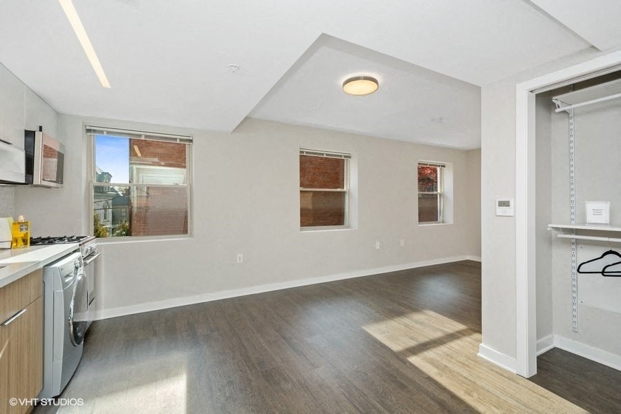 a kitchen and living room with white walls and wood floors at Carver and Slowe Apartments, Washington