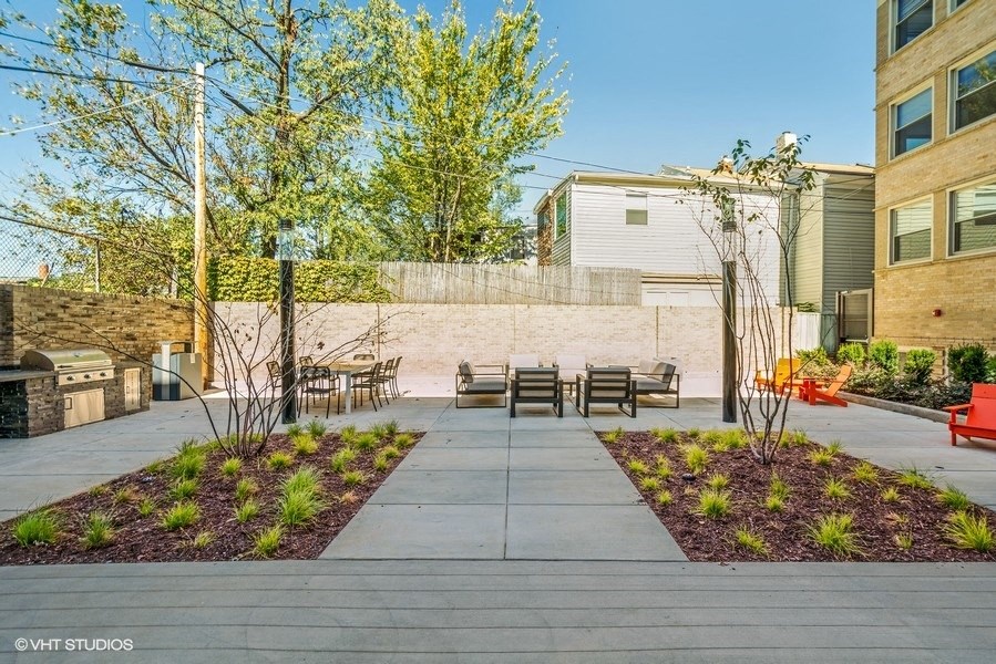 an outdoor patio with chairs and a grill at Carver and Slowe Apartments, Washington Washington, DC