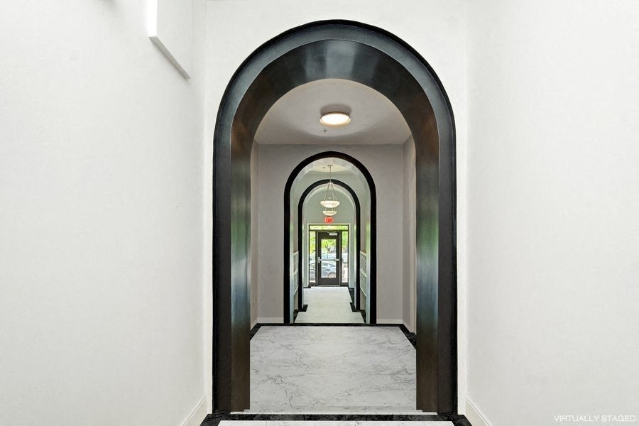 a view down a hallway with a black and white archway and white walls
