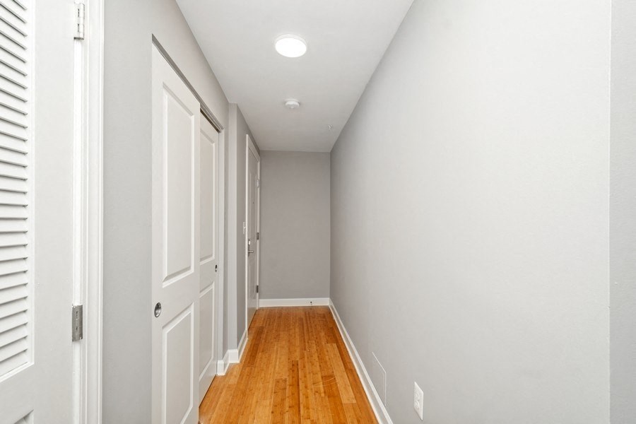 a hallway with grey walls and a wooden floor