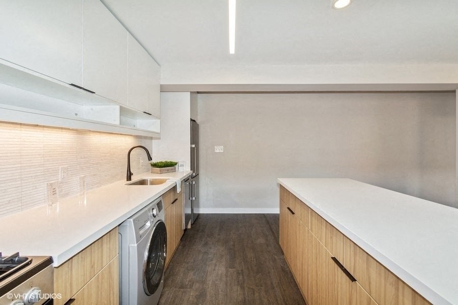 a kitchen with white countertops and wooden cabinets at Carver and Slowe Apartments, Washington, DC