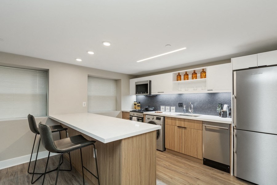 a kitchen with white countertops and wooden cabinets at Carver and Slowe Apartments, Washington, DC