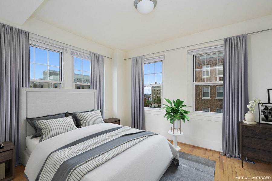 a bedroom with a bed and three windows