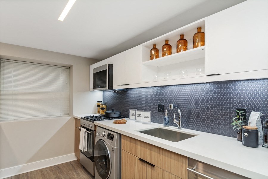 a kitchen with white countertops and a stainless steel sink at Carver and Slowe Apartments, Washington, DC, 20001