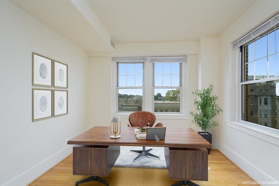 a home office with two windows and a wooden desk
