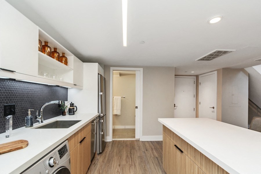 a kitchen with white countertops and wooden cabinets at Carver and Slowe Apartments, Washington, DC, 20001