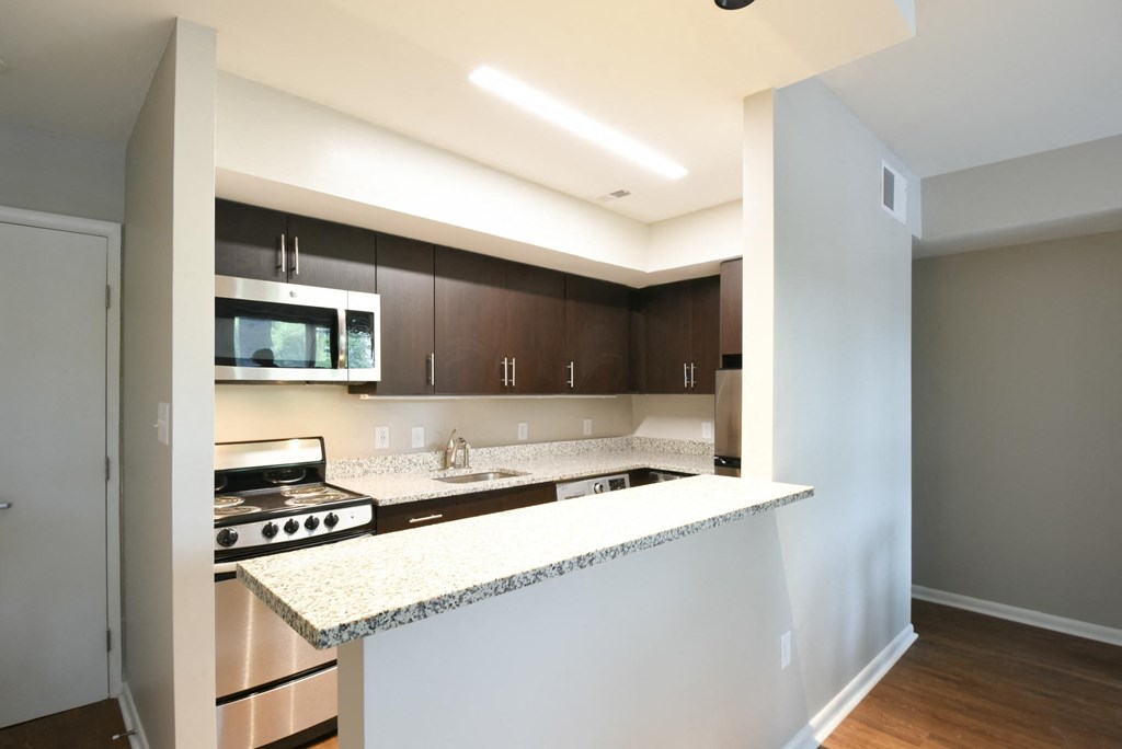a kitchen with white countertops and dark wood cabinets