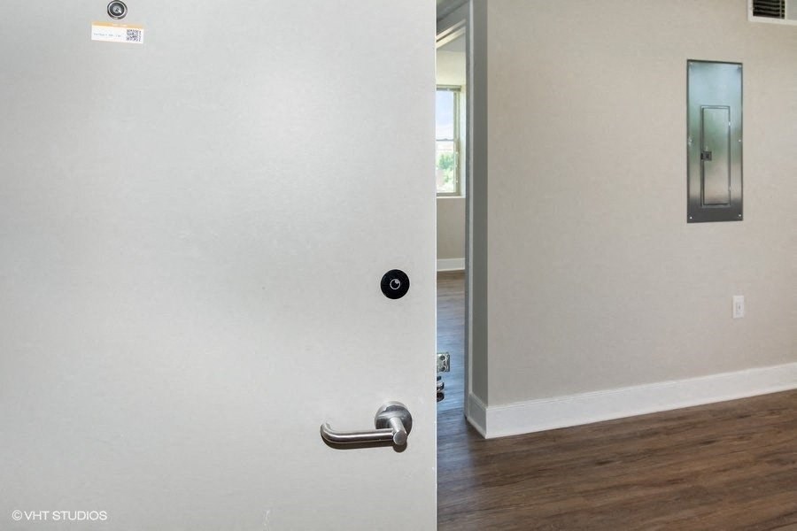 a white door with a silver handle and a hallway in the background at Carver and Slowe Apartments, Washington Washington, DC