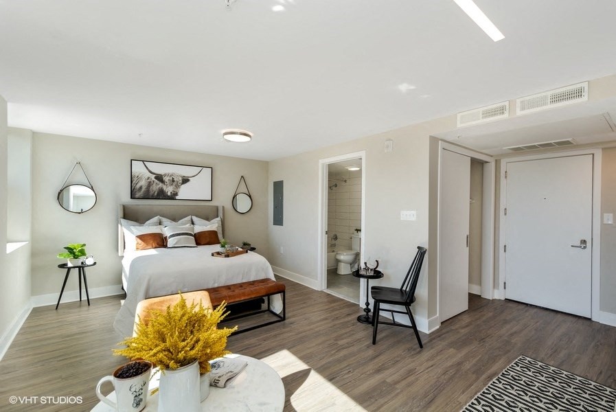 a bedroom with a large bed and a bathroom in the background at Carver and Slowe Apartments, Washington, Washington, DC 20001