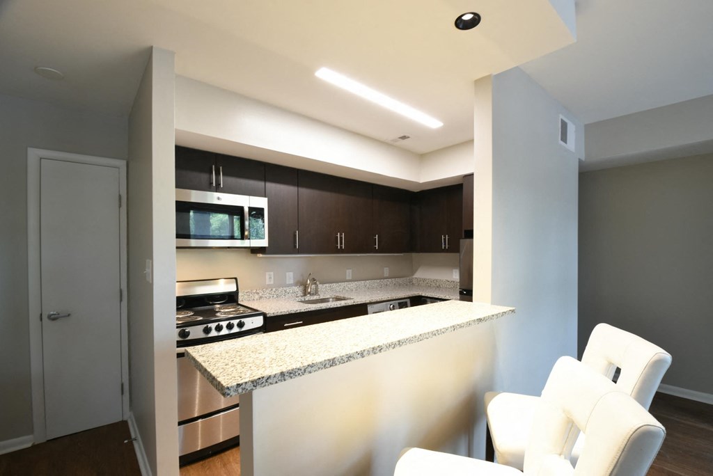 a kitchen with an island and white chairs