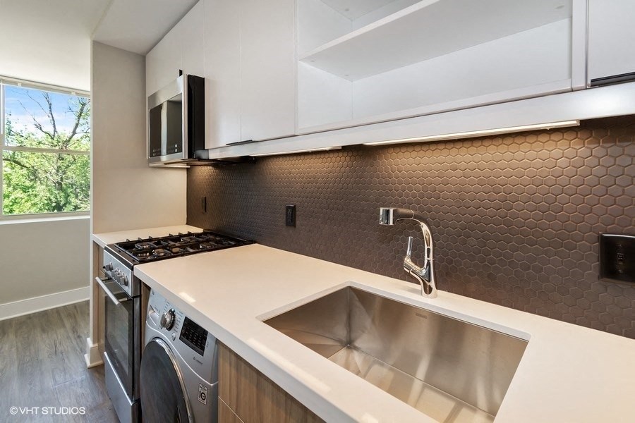 a kitchen with white countertops and a stainless steel sink at Carver and Slowe Apartments, Washington, DC