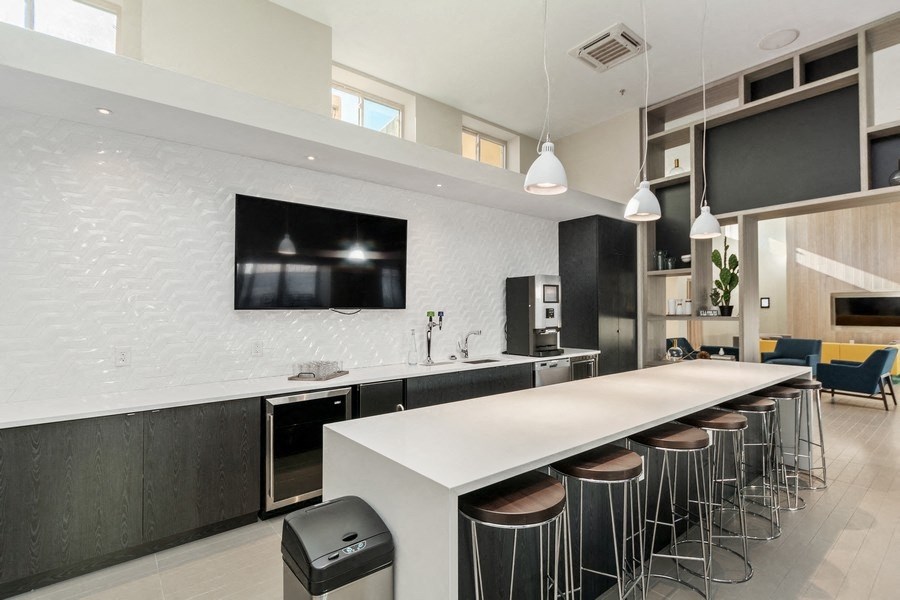 a kitchen with a long white counter and a long row of stools in front of it at Carver and Slowe Apartments, Washington, DC