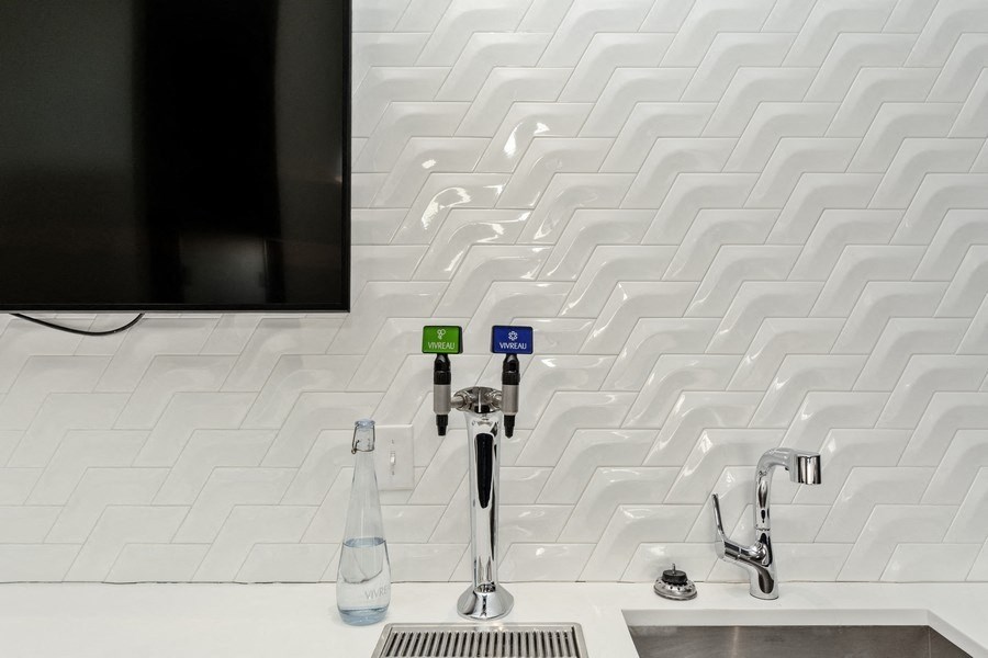 a kitchen sink with a tap and a tv on the wall at Carver and Slowe Apartments, Washington Washington, DC