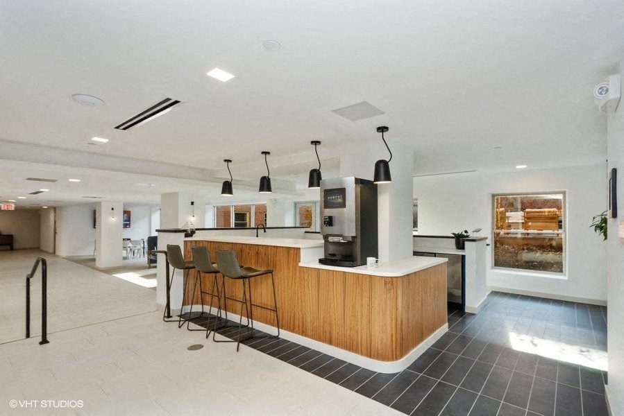 a lounge kitchen with a long counter and a row of chairs at Carver and Slowe Apartments, Washington