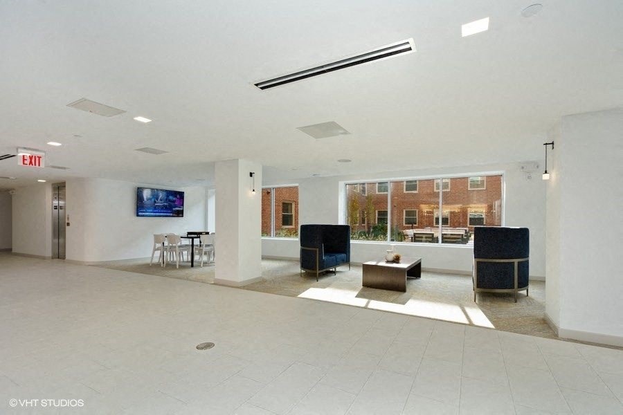 a lobby with a tv and a table with chairs at Carver and Slowe Apartments, Washington, DC, 20001