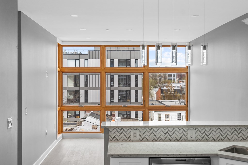 A kitchen with a large window overlooking a cityscape.