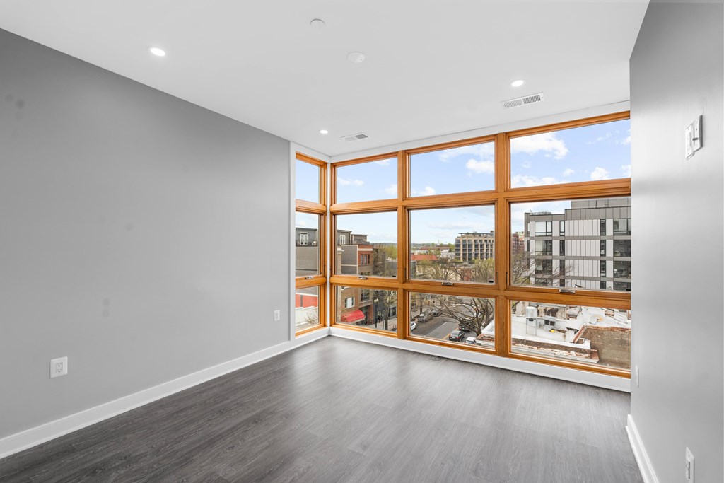 A room with a large window and a view of the city.