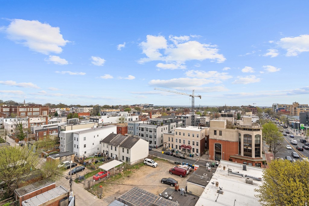 A cityscape with buildings and cars under a blue sky.