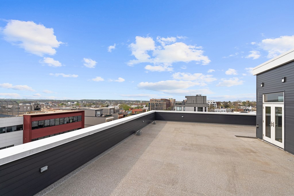 A rooftop with a building and a clear blue sky.