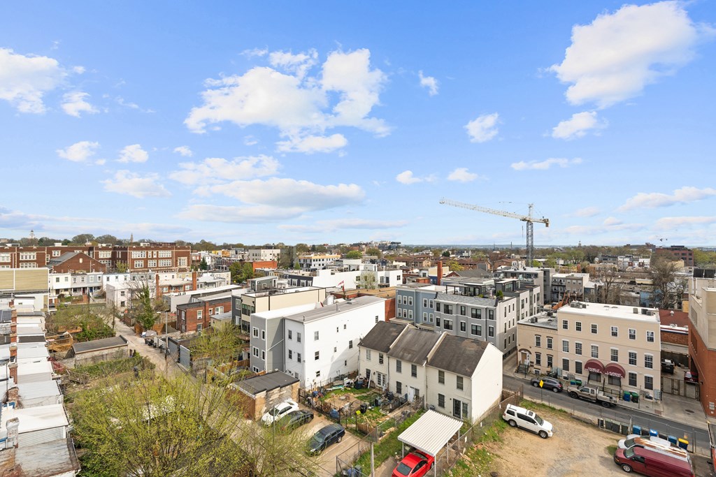 A view of a town with buildings, cars, and a crane.